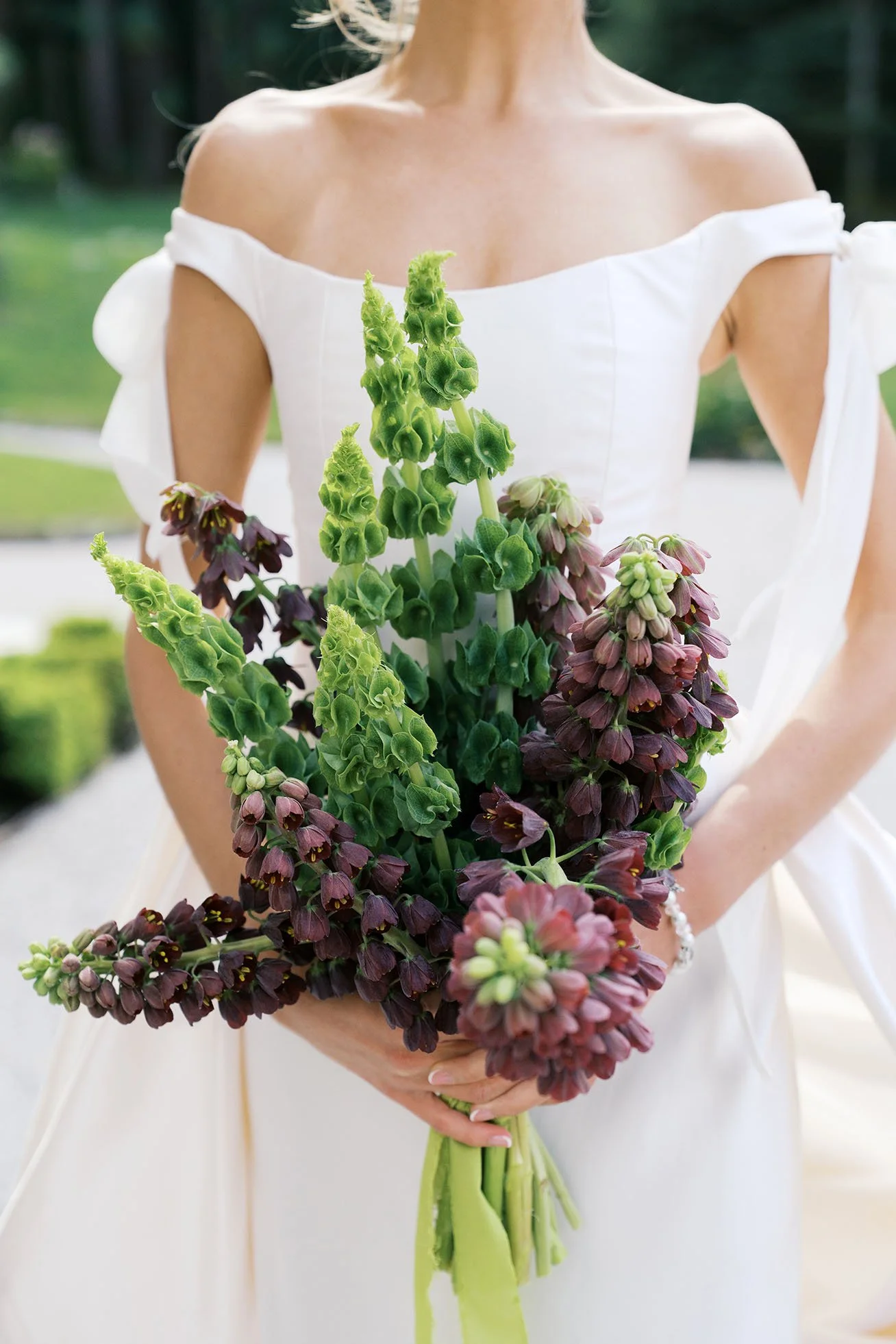 A close-up shot of a bride holding a bridal bouquet.