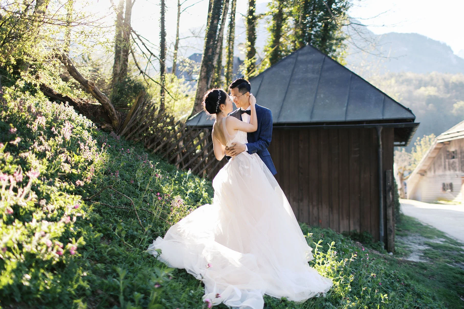 A wedding couple wearing wedding attire posing at a garden in Königsee, Germany for their elopement