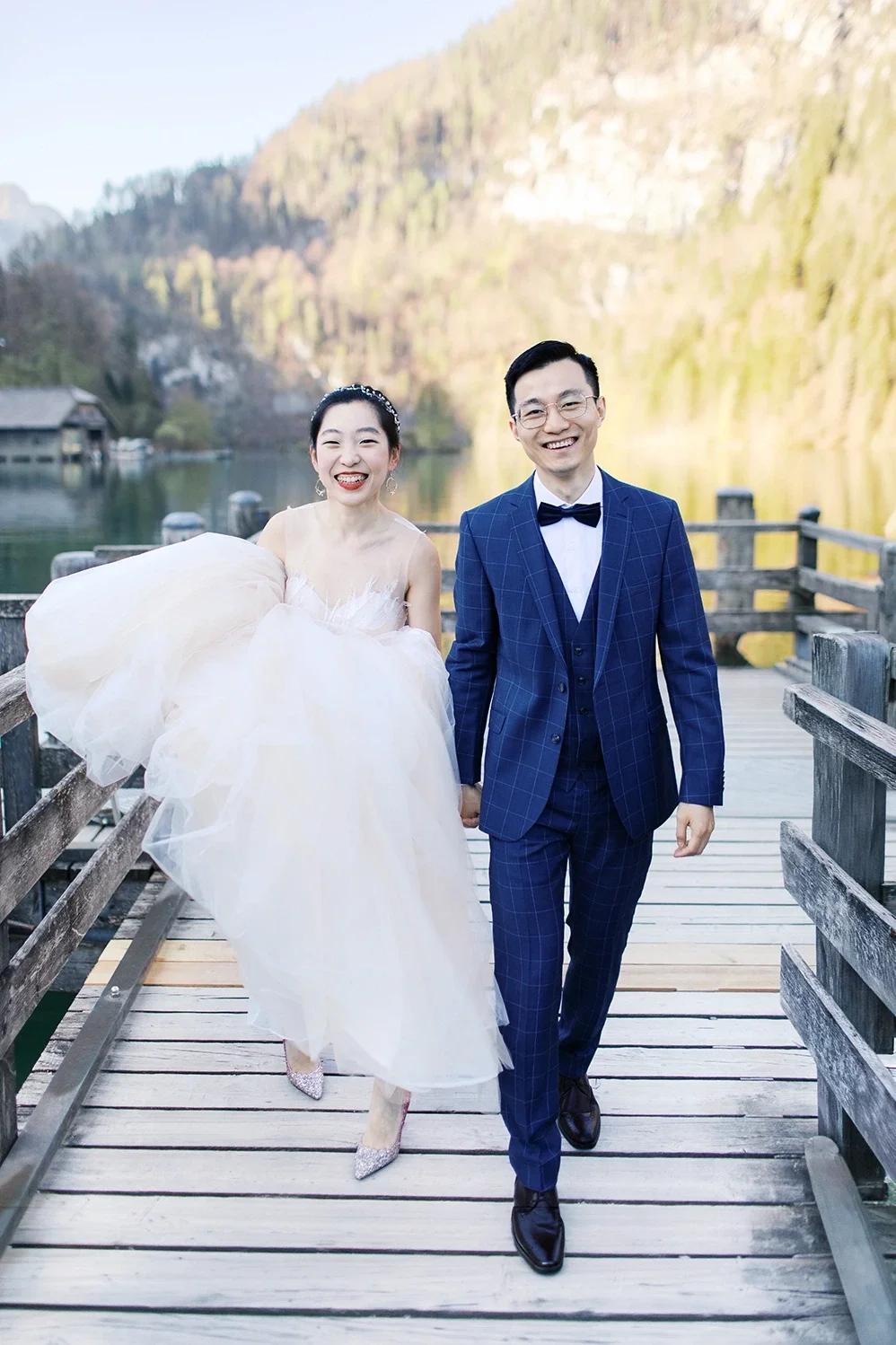 Smiling wedding couple walking at Königsee in the south of Germany