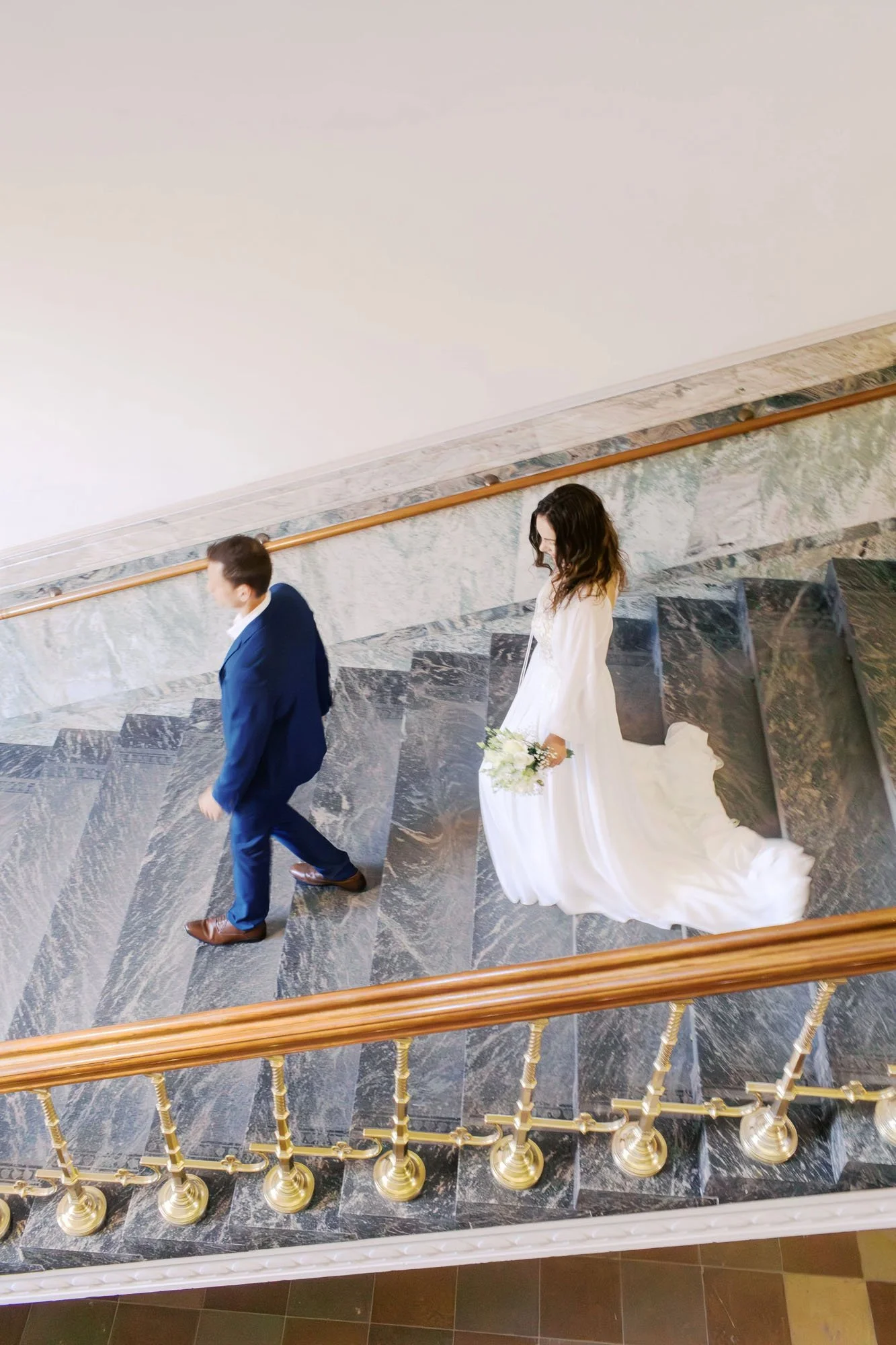 Couple walking down the stairs on their wedding day in Berlin, taken by Duo Chen Photography