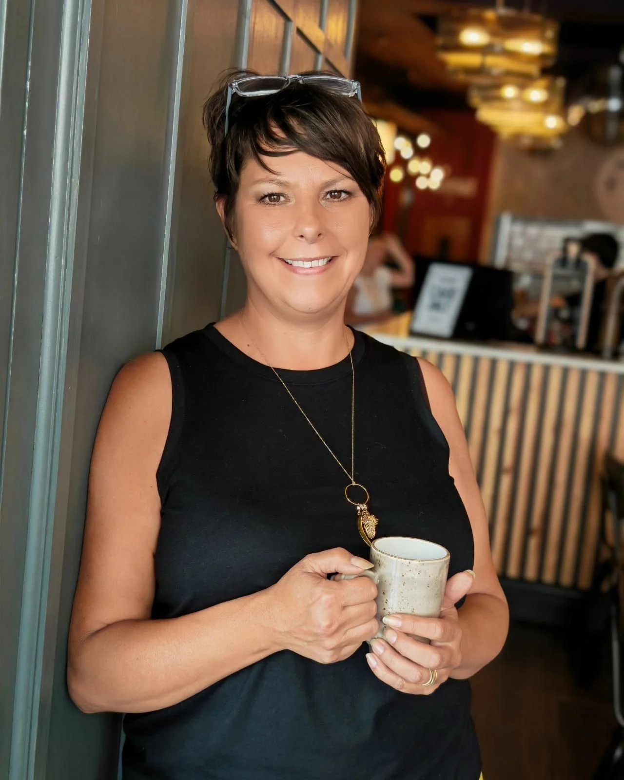 Helen smiling warmly with a cup of tea