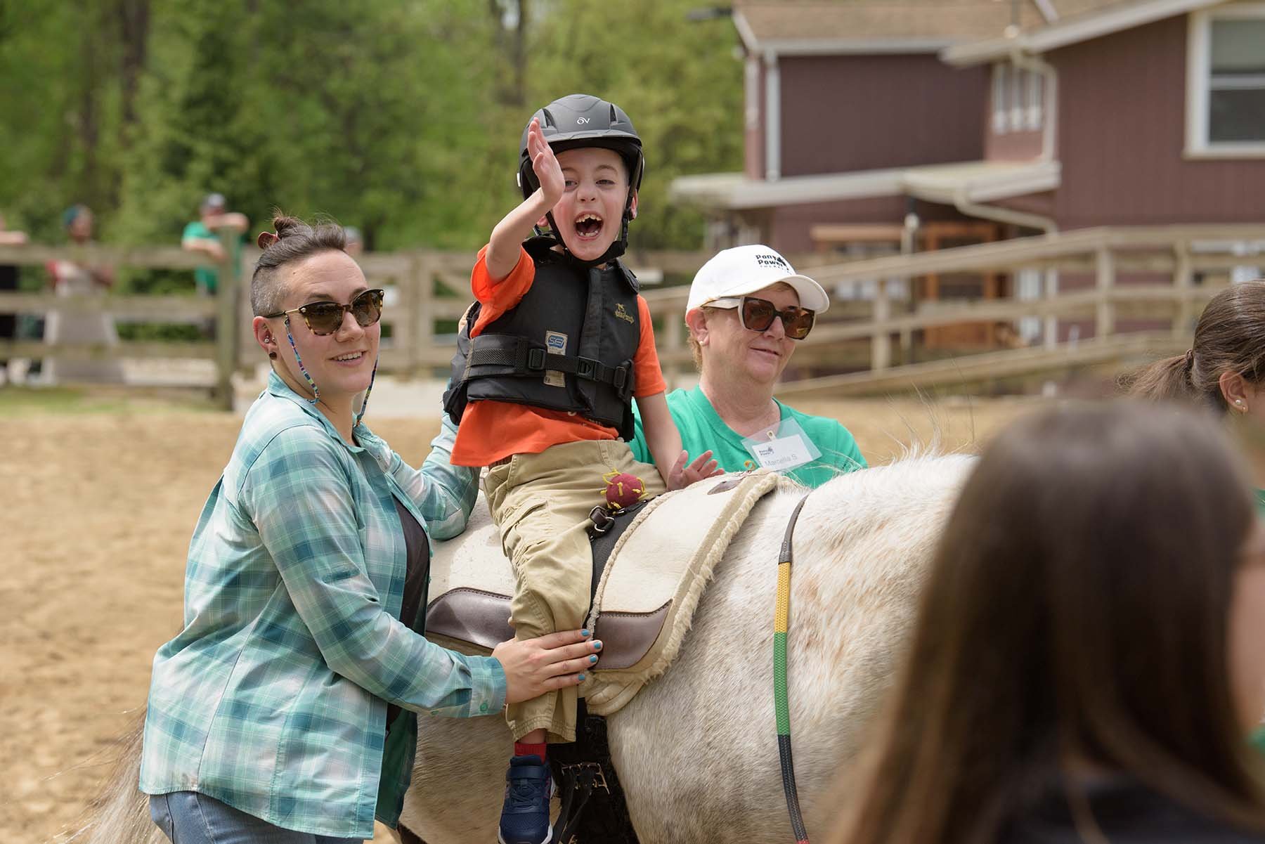 A young boy smiles as he rides a horse