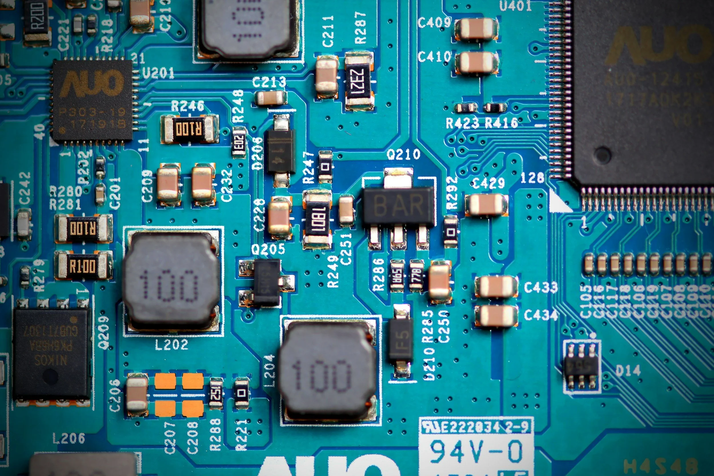 Close-up of a blue circuit board with microchips, representing semiconductor manufacturing and technology Strategic Sectors for Japan Investment.