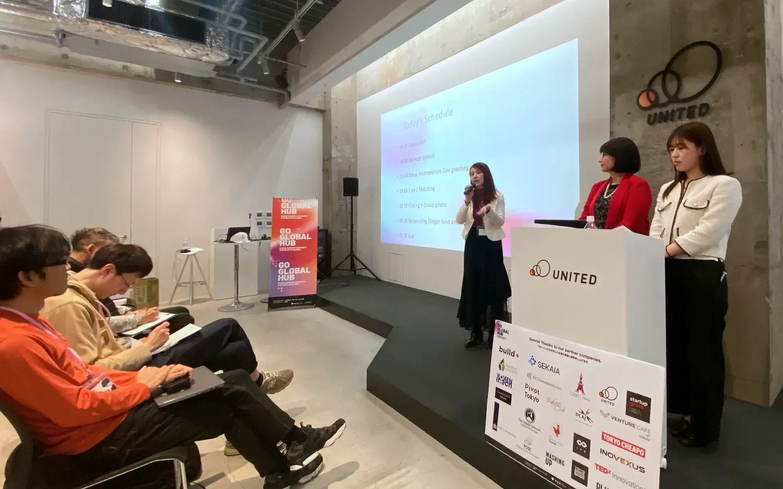 Moeko Suzuki, founder of Startup Lady, addresses the audience at the Global Connector Salon alongside the leadership team, outlining the schedule for the Startup Ecosystem event.