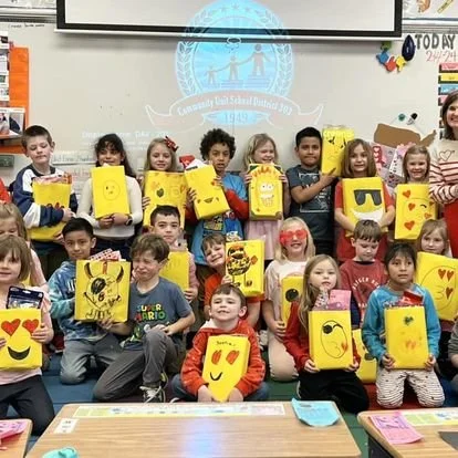 Students holding art projects in a Davis classroom