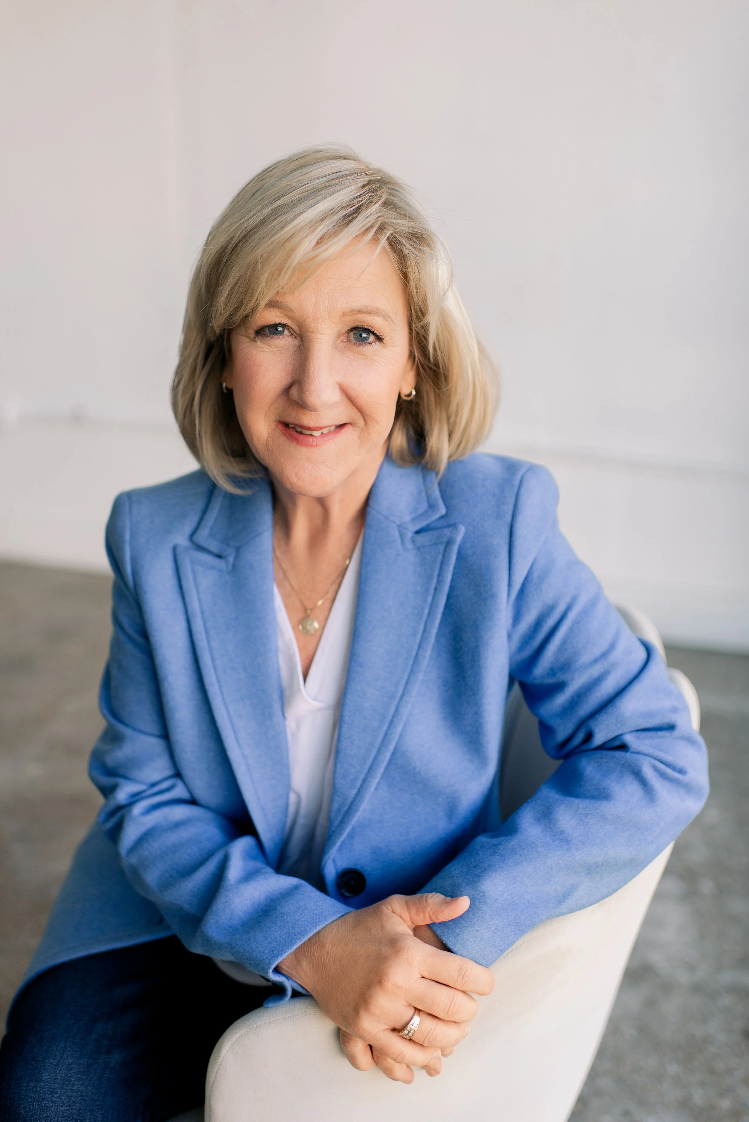 A therapist who specializes in women's intimacy issues sits in a chair smiling at the camera.