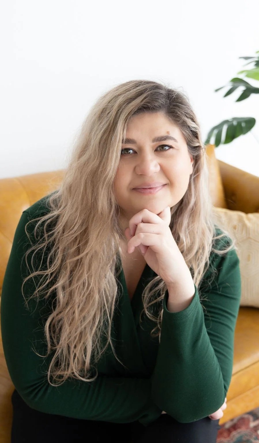 A counselor who provides therapy for overwhelmed mothers gazes with a slight smile in front of her.