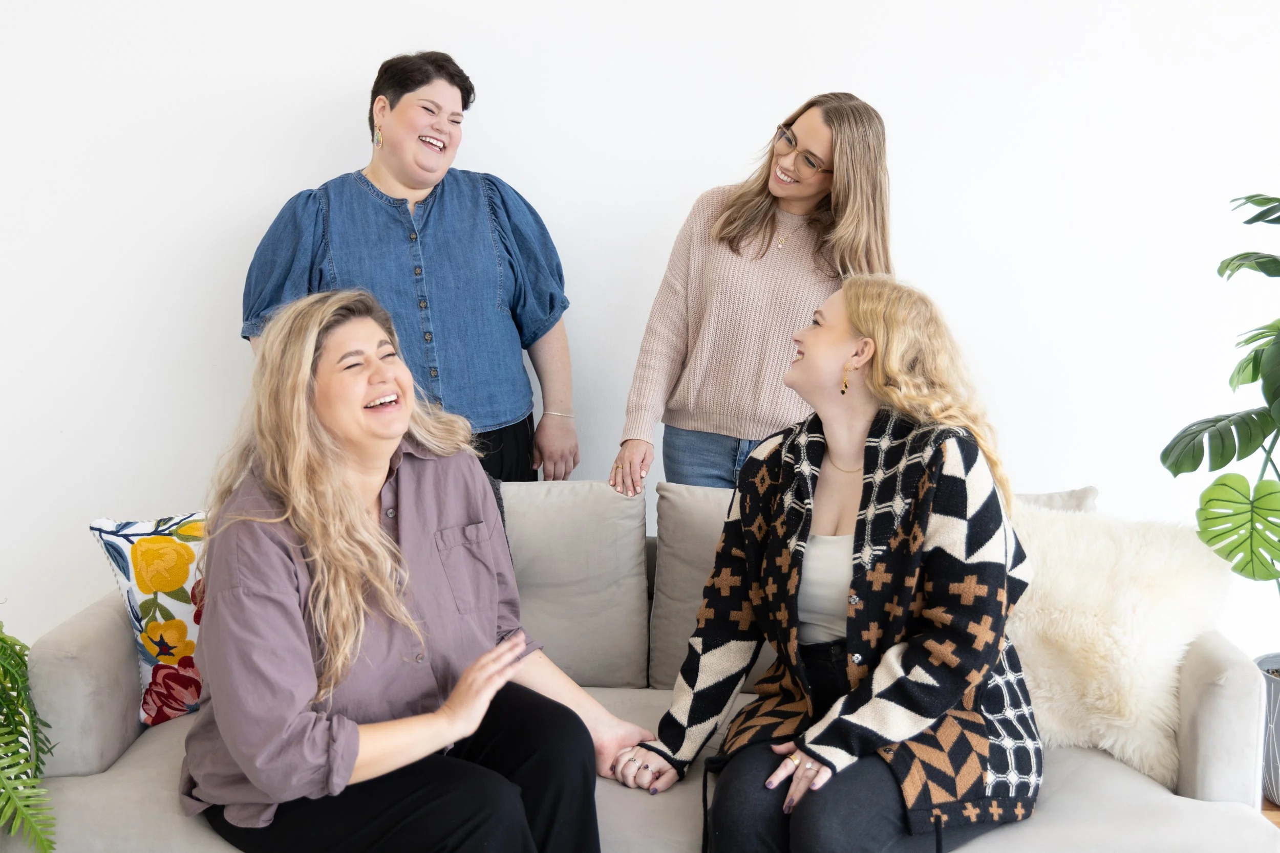 A group of therapists who provide relational trauma therapy and therapy for intimacy issues are having a conversation and laughing together.