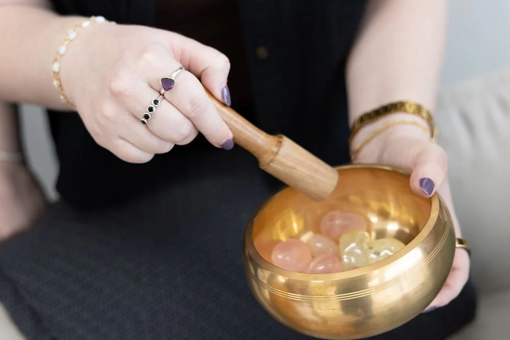 A counselor who provides couples therapy in plano holds a sounding bowl filled with crystals.