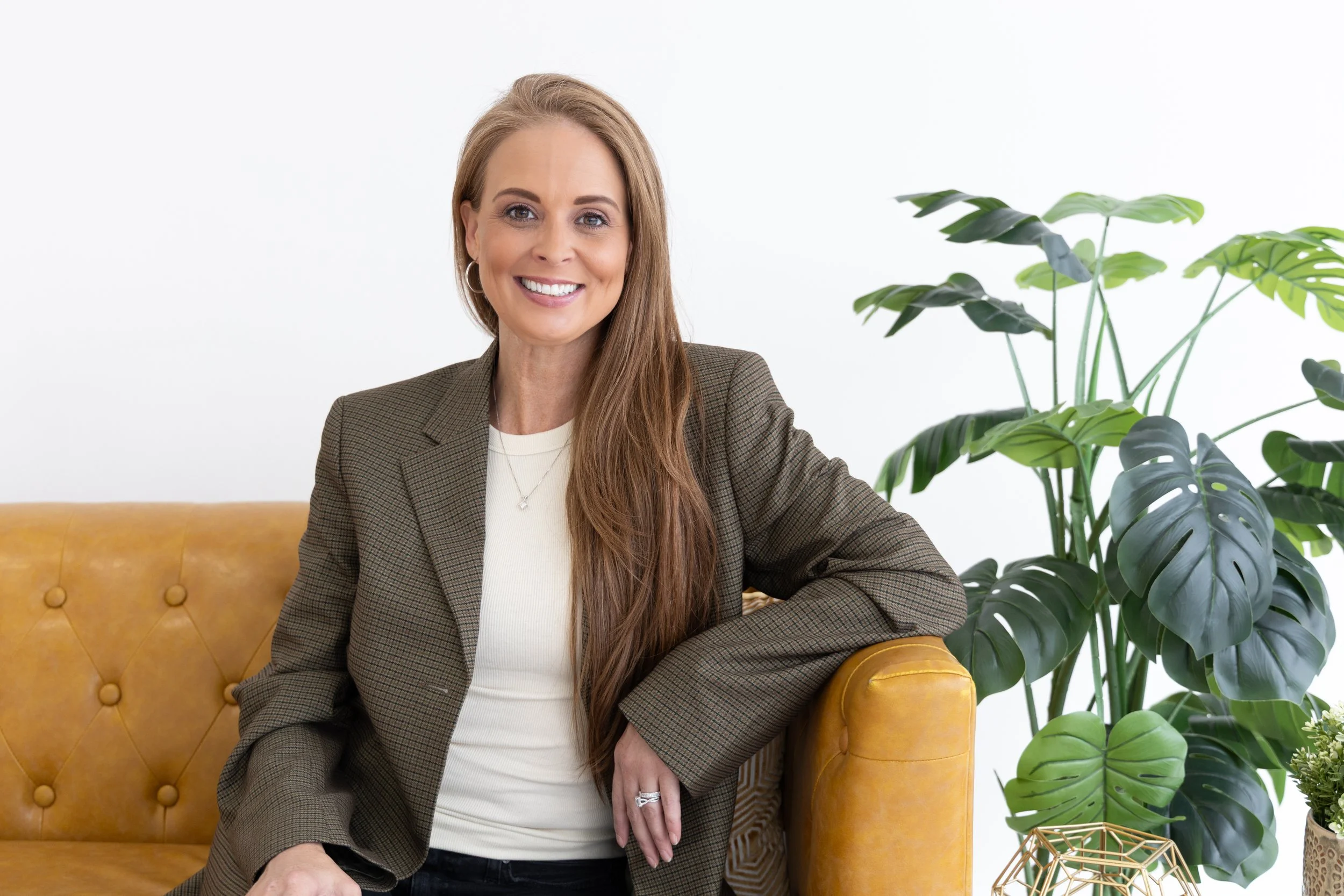 A therapist in Plano sits on a couch while teaching a client about how to initiate a nervous system reset.