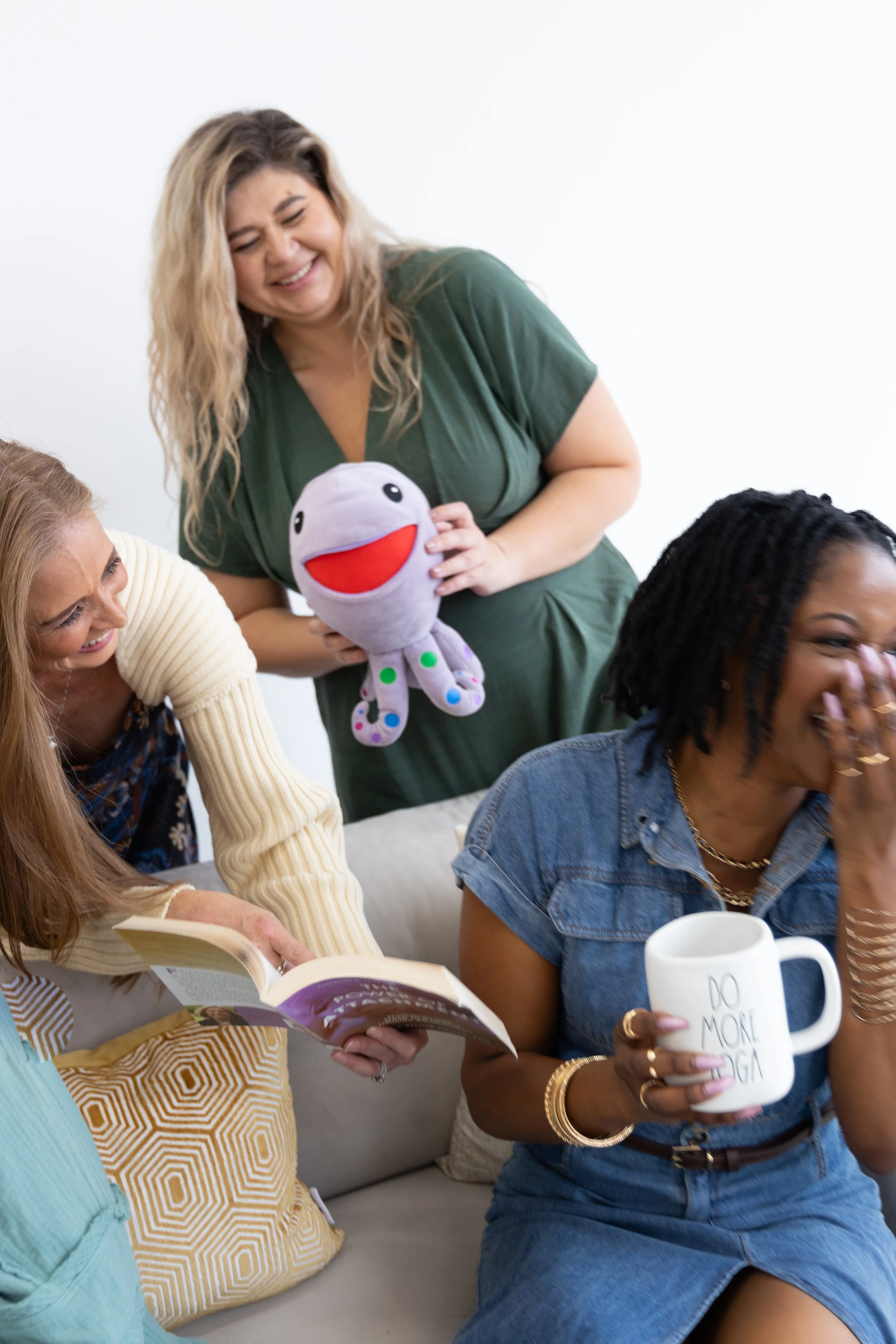 Three Plano therapists look at at each other and laugh while holding therapeutic tools used for adhd testing in Plano.