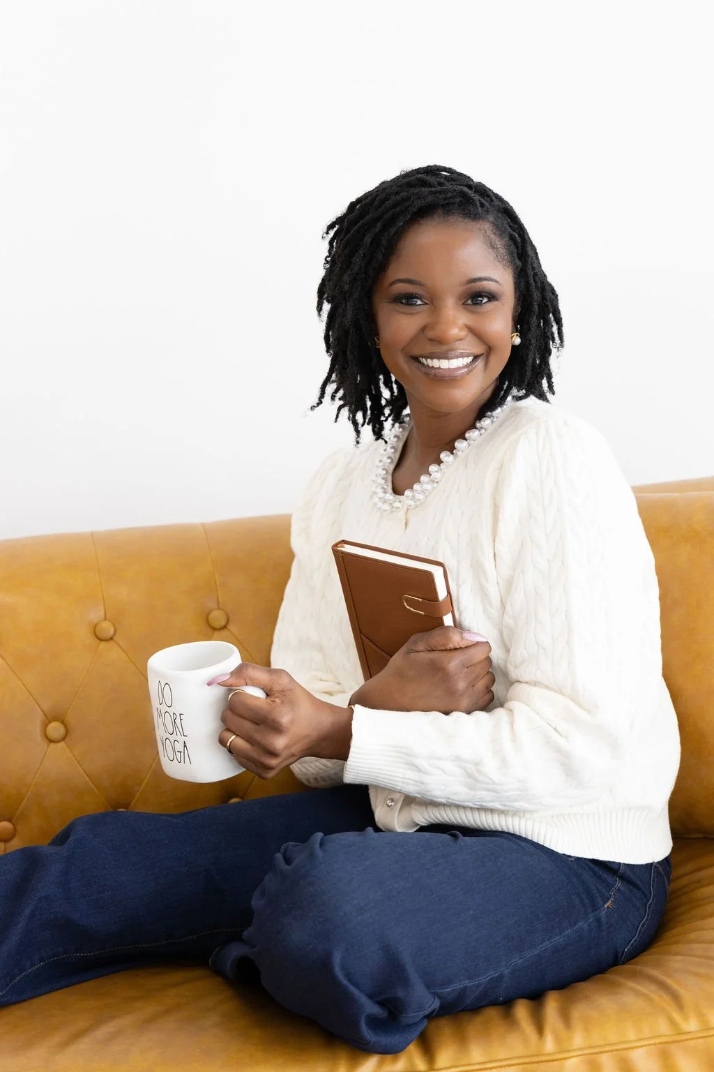 An authentic therapist in Plano holds a book and a cup of coffee while providing therapy for feeling stuck.
