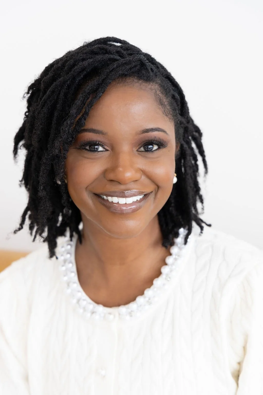 A somatic therapist near me who provides body based healing smiles while talking with a client.