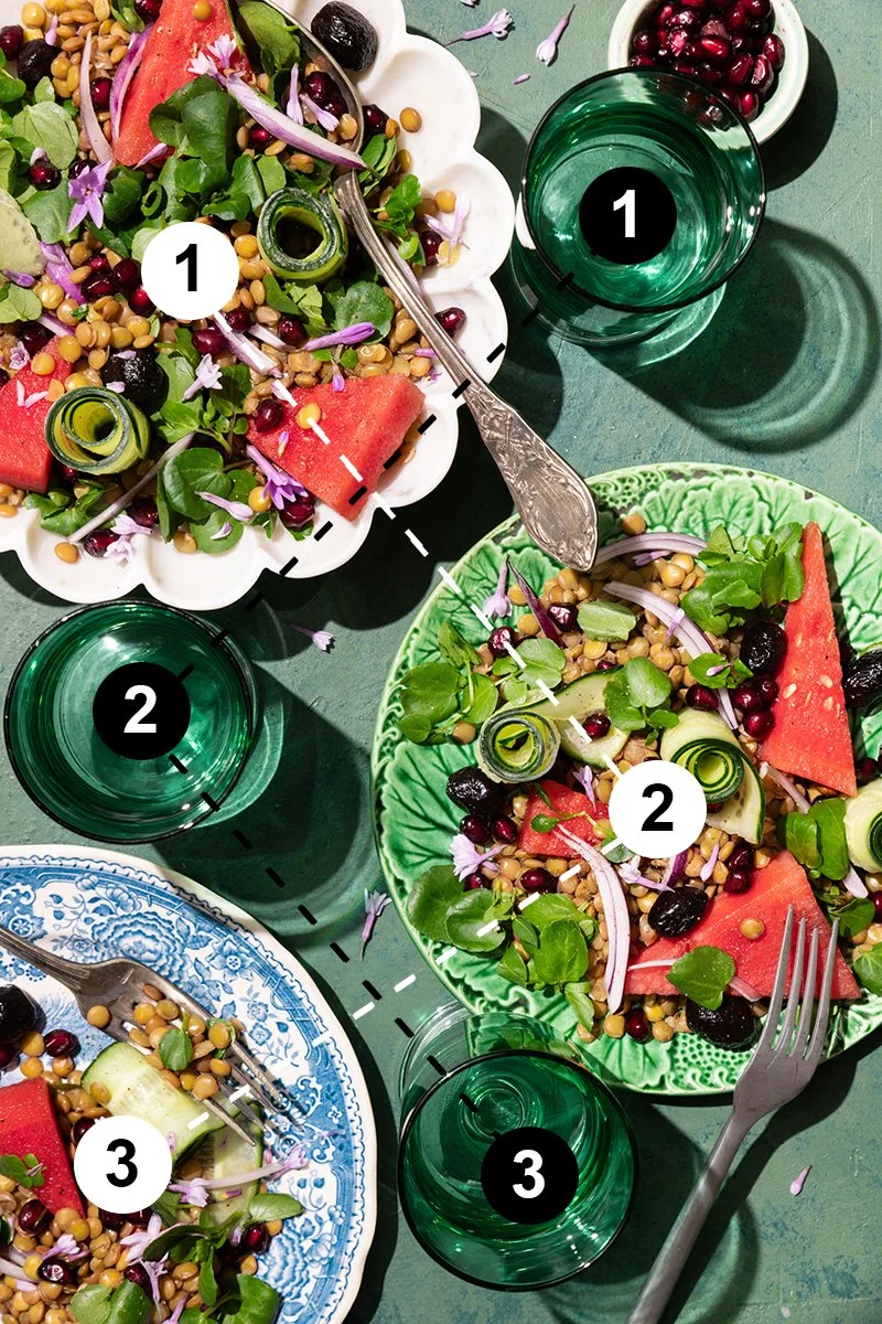 Salade de cresson, courgette et pastèque présentée dans 3 assiettes, avec 3 verres d'eau de couleur verte