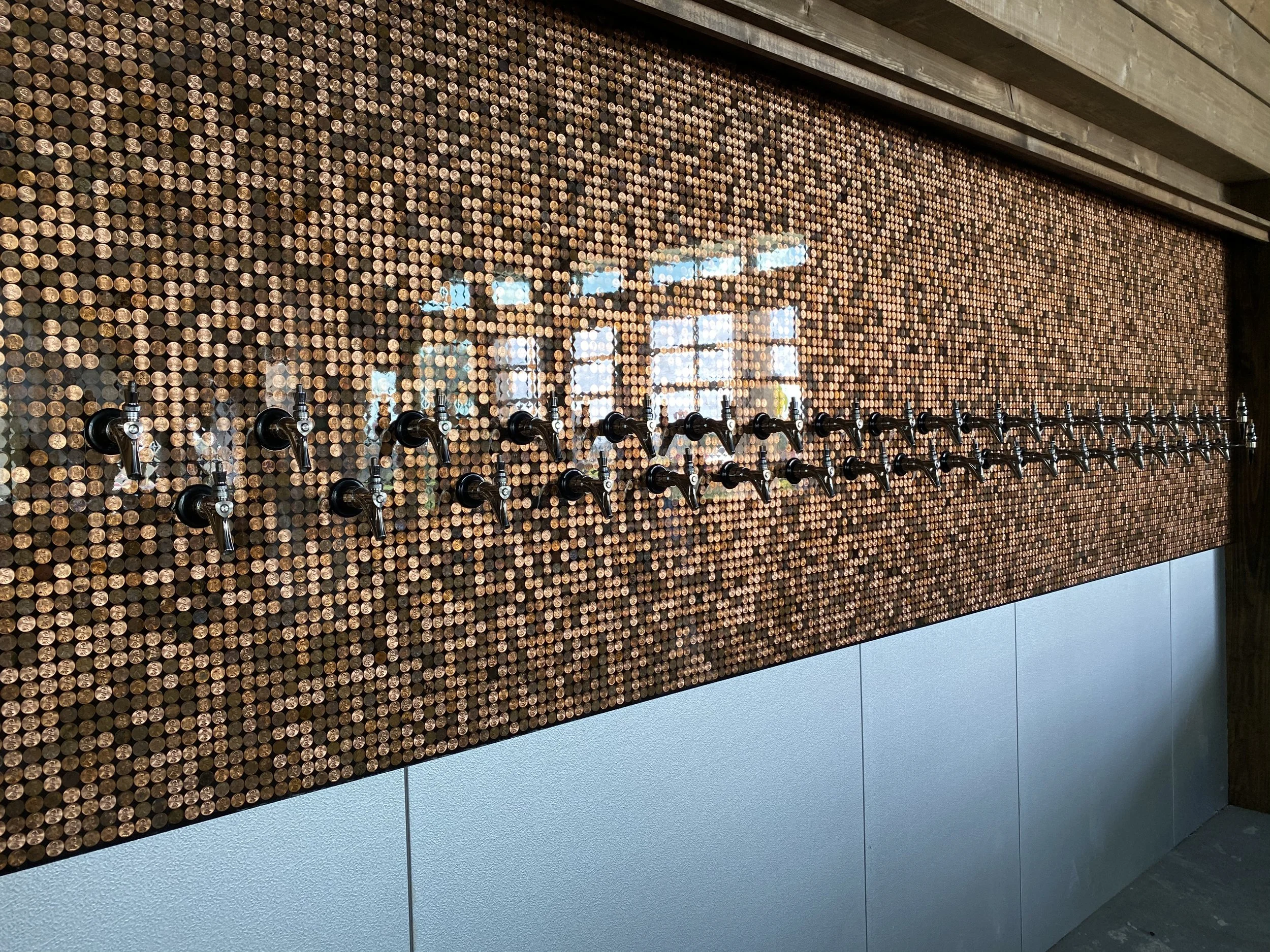 Close-up of a wall decorated with numerous beer faucets
