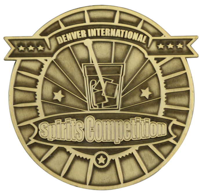 Medal for the Denver International Spirits Competition featuring a beer glass with swirling liquid and cards, stars, and gears design elements.