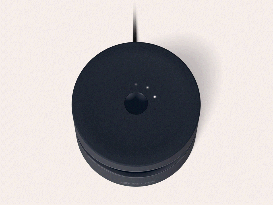 Top view of a black Amazon Echo device with four small indicator lights and a circular black button in the center.