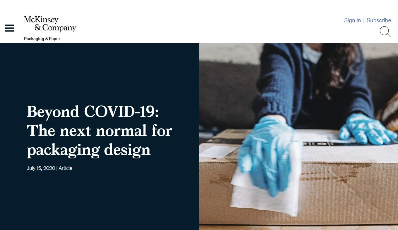 A person wearing blue gloves taping a shipping label onto a cardboard box.