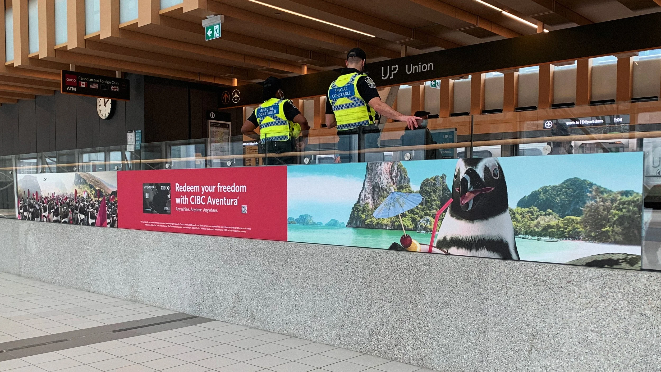 A train station billboard showing an army of penguins.