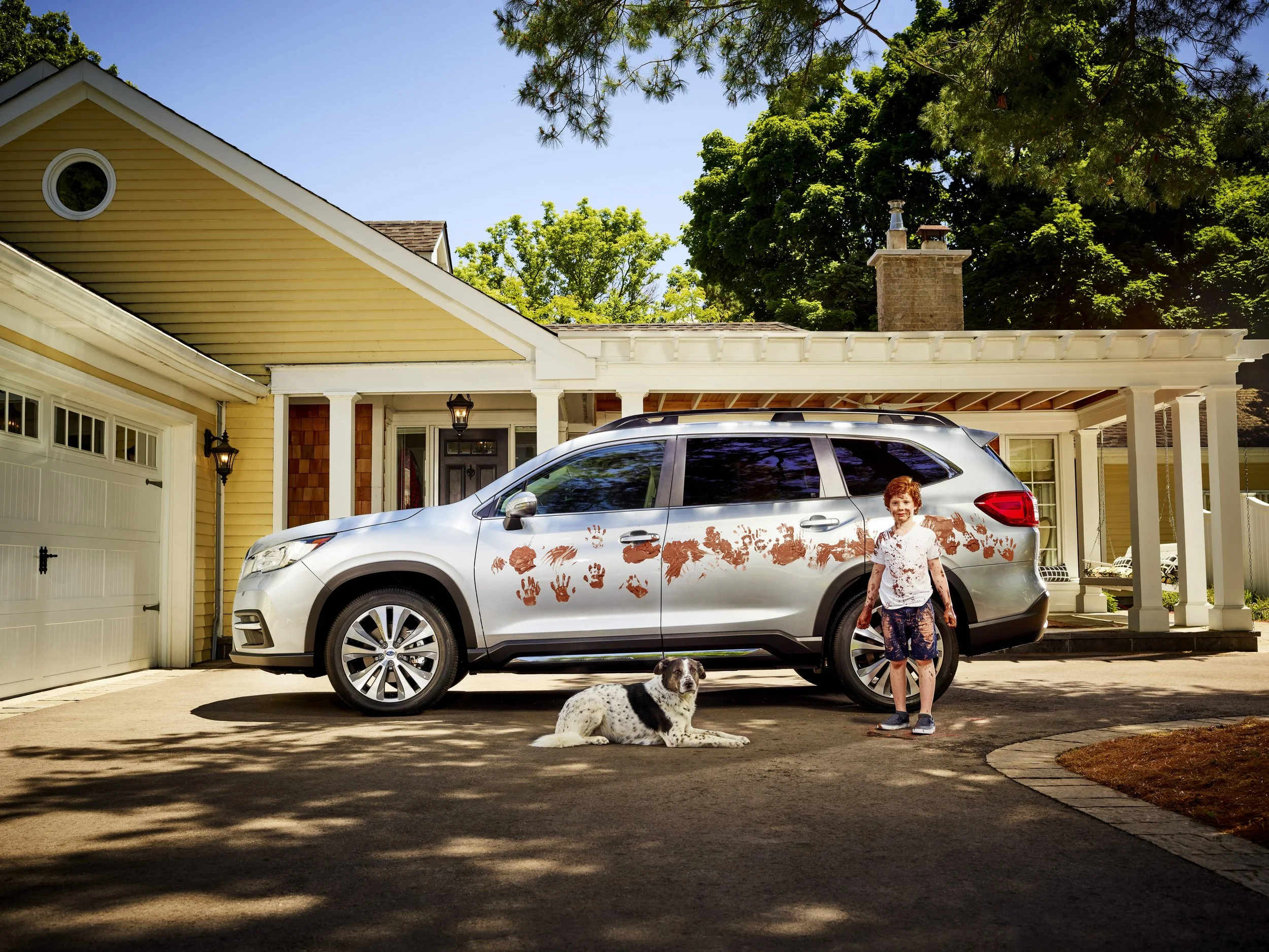 An image of a kid near a muddy car
