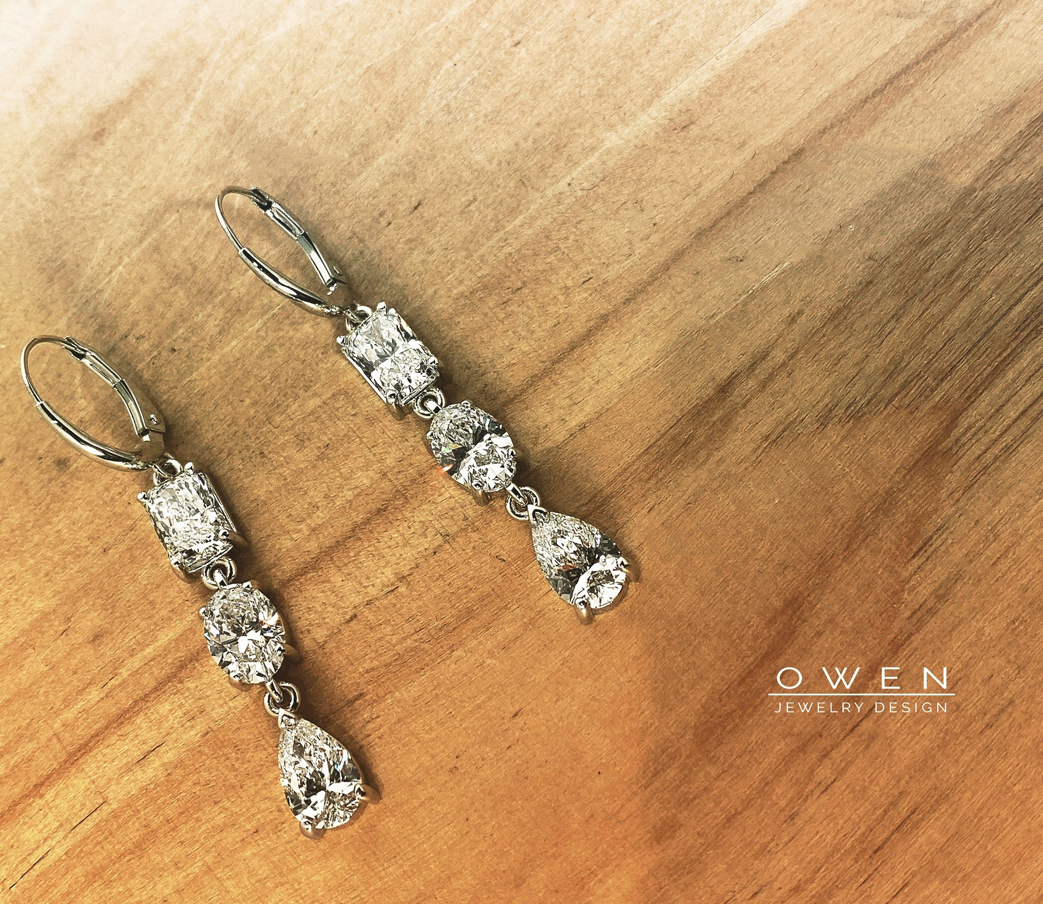 CUSTOM WHITE GOLD DANGLE EARRINGS CONTAINING RADIANT CUT, OVAL BRILLIANT CUT, AND PEAR SHAPED DIAMONDS.jpg