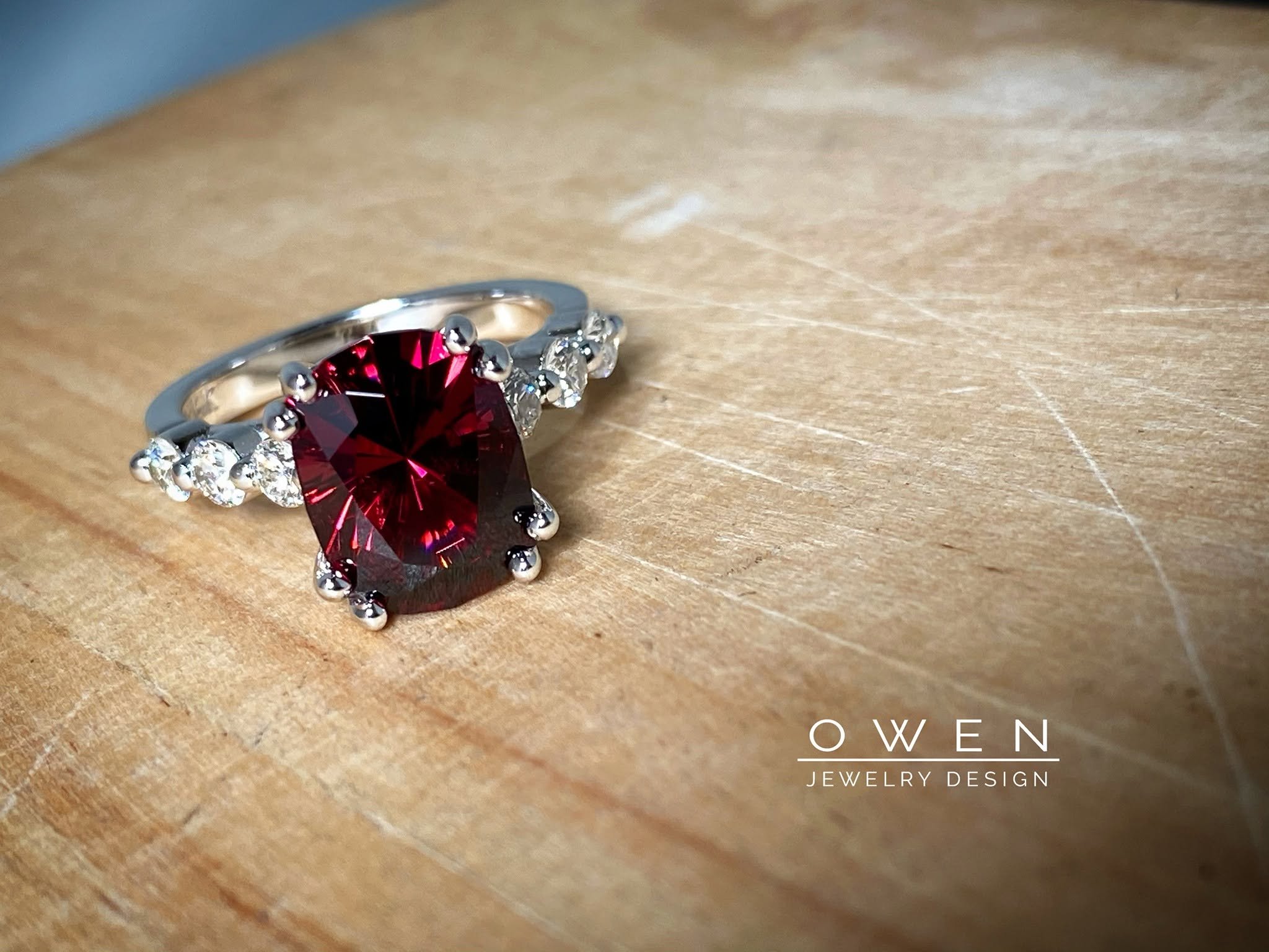CUSTOM WHITE GOLD RING WITH A CUSHION CUT RHODOLITE GARNET AND ROUND ACCENT DIAMONDS.jpg
