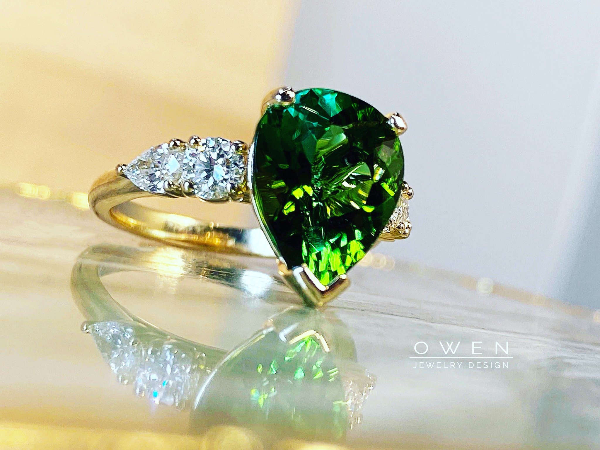 CUSTOM YELLOW GOLD RING WITH GREEN TOURMALINE, ROUND SHAPE DIAMONDS, AND PEAR SHAPE DIAMONDS.jpg