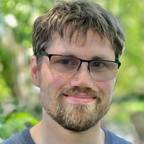 White man with short light brown hair and a goatee wearing glasses