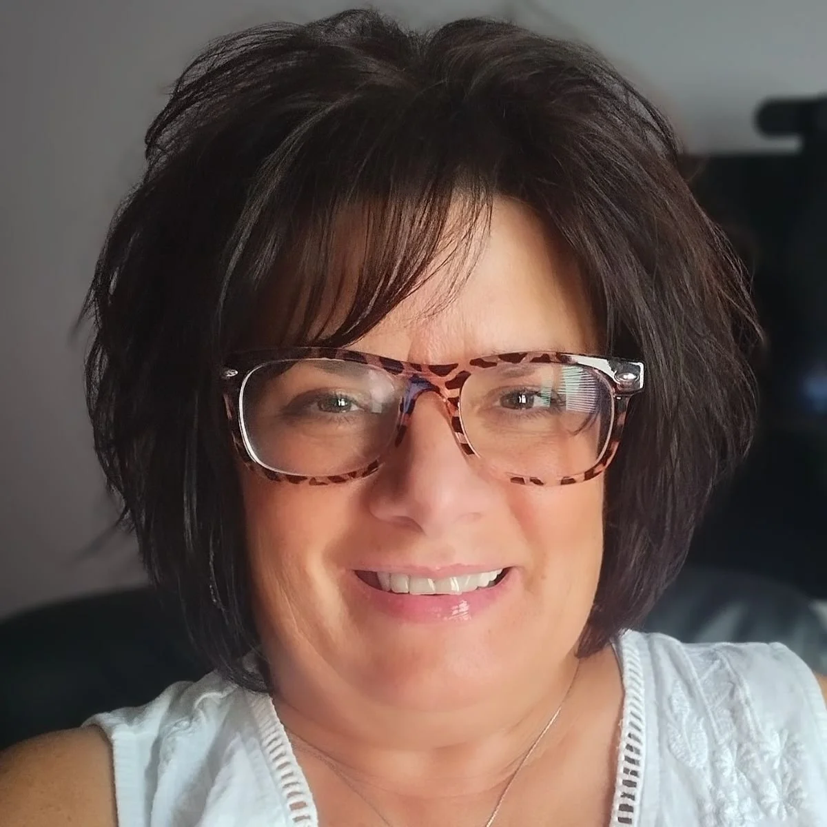 Woman with short dark hair wearing glasses