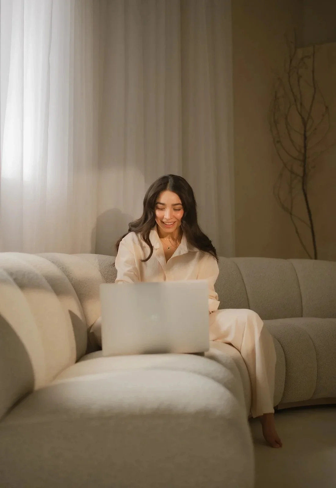 Los Angeles web designer sitting on a couch working on her laptop