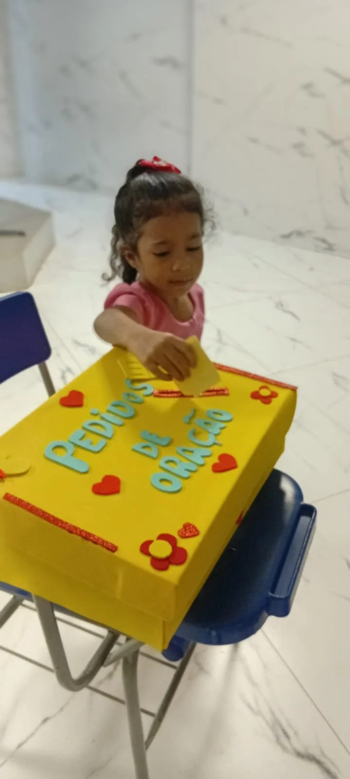 A child using a prayer box in Red Viva  Protege Brasil