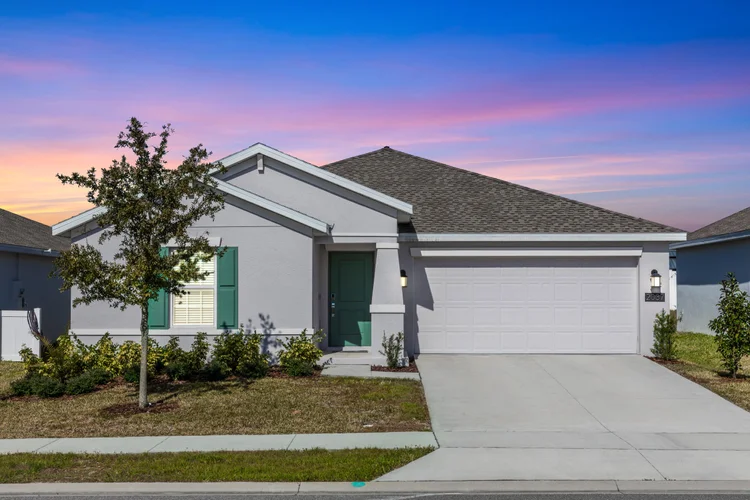 A single-story modern suburban house with light gray exterior, dark gray shingle roof, green shutters, and a white garag