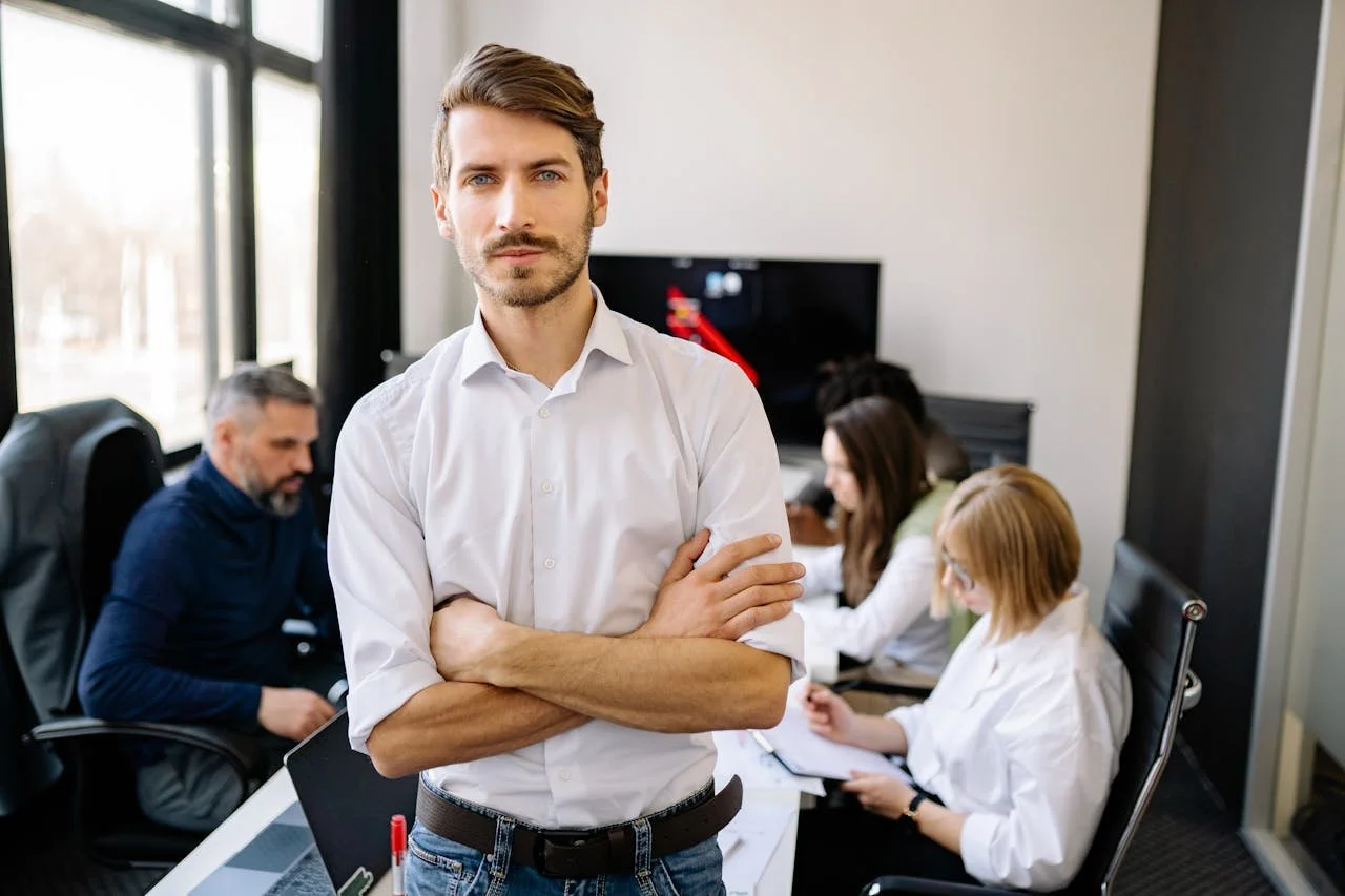 Man in white short in board room meeting looking at camera