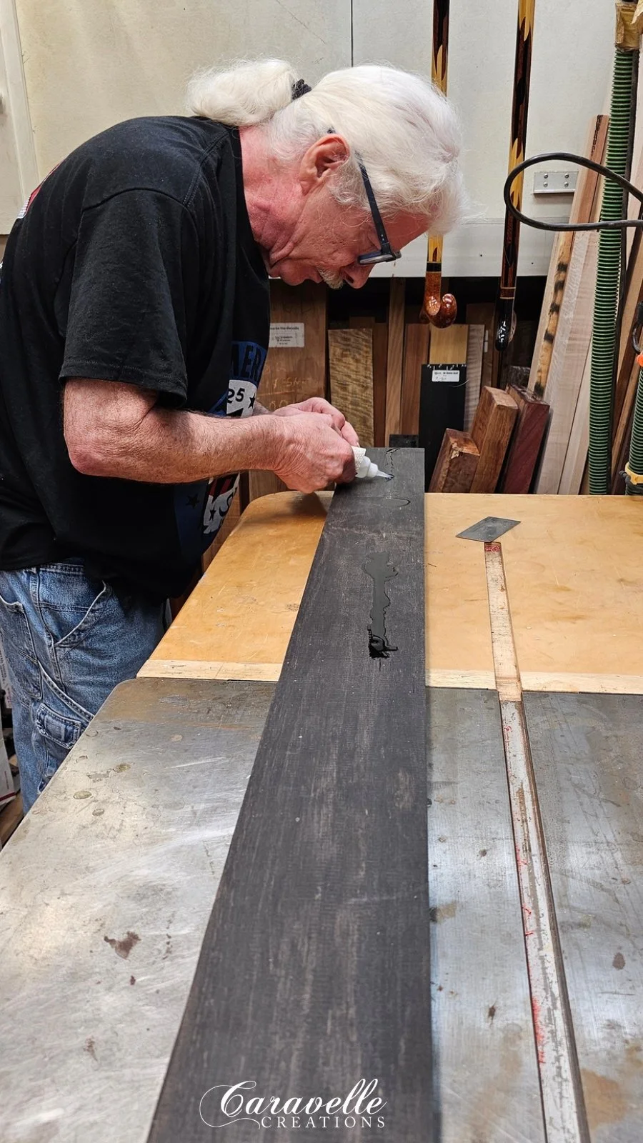 Jim Wallace in his shop working with a raw plank of ebony wood