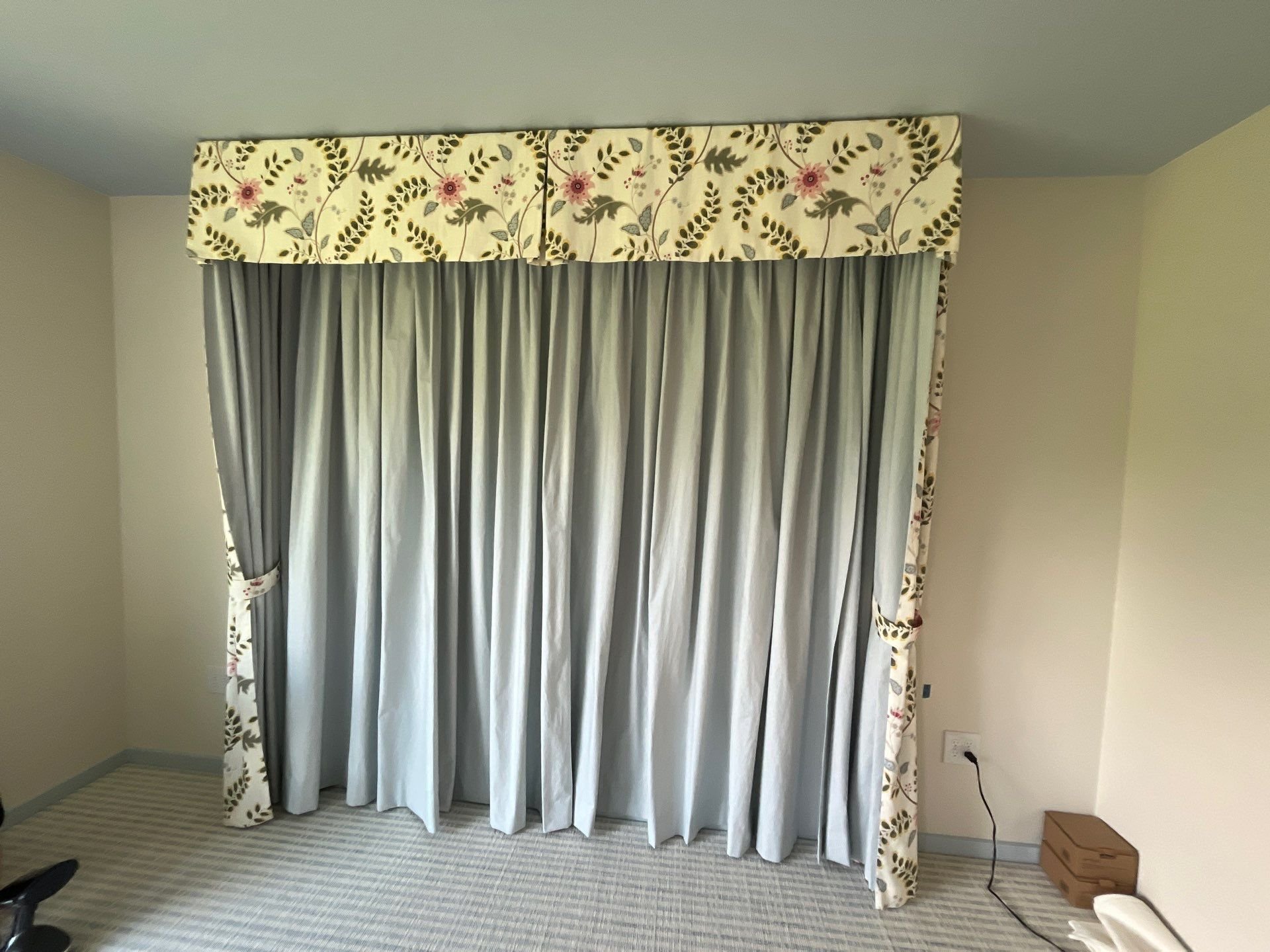 Contrasting interior and exterior fabric draping around the head of the bed with tie backs and a valance top.