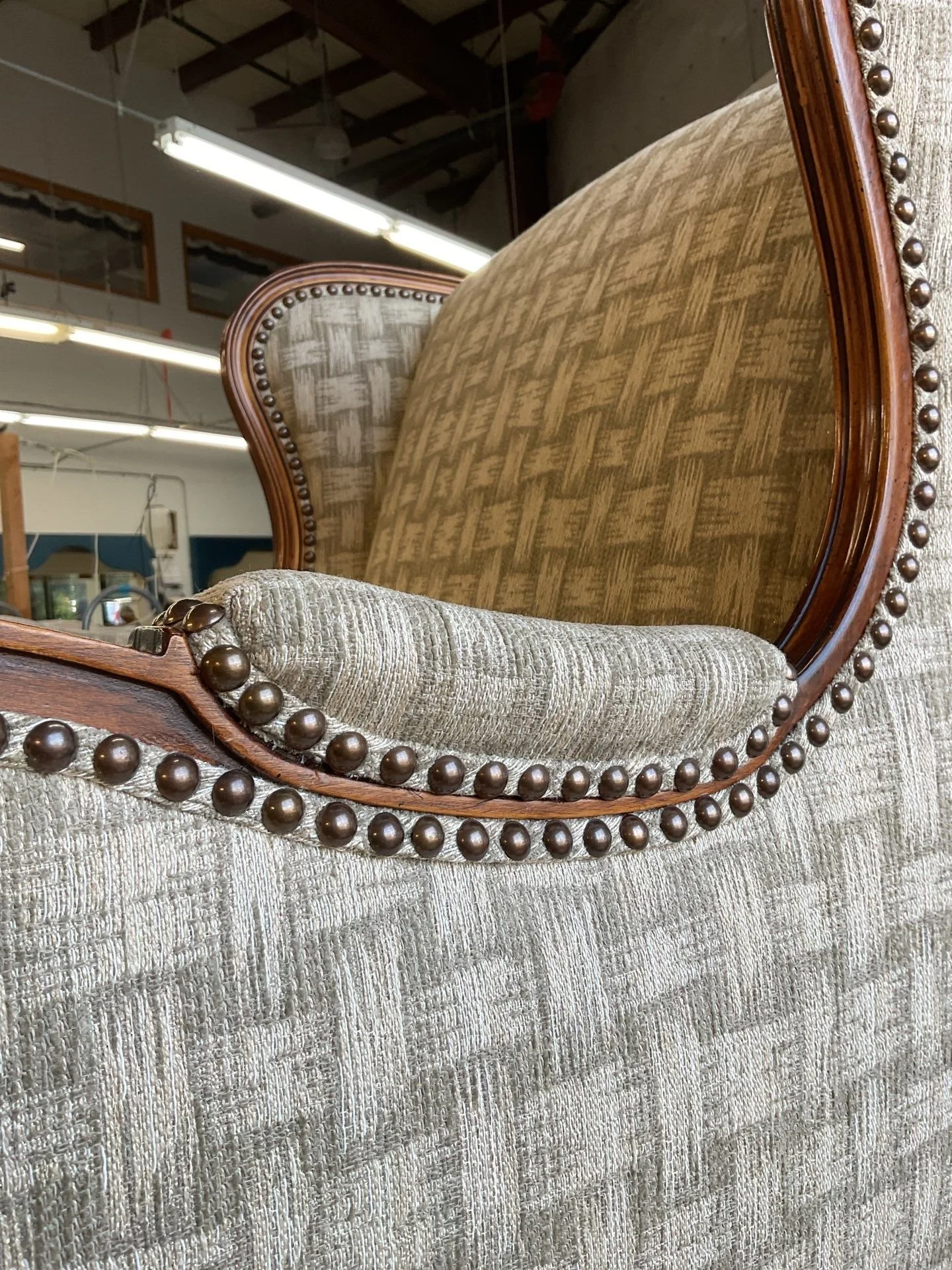 Vintage armchair before reupholstery during inspection in LP Studio upholstery workroom