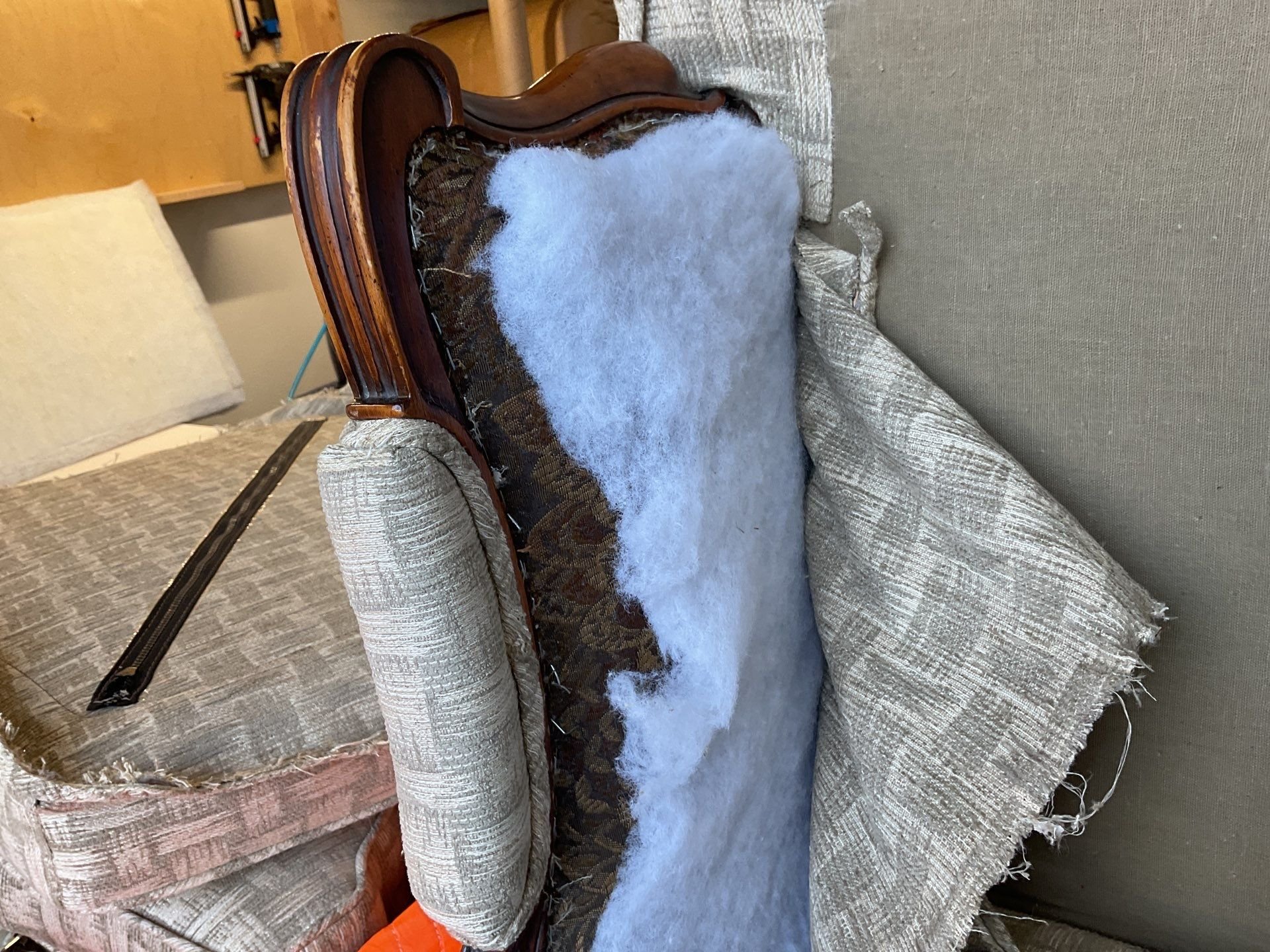 Upholsterer hand-tailoring new fabric on a custom chair frame in Seattle