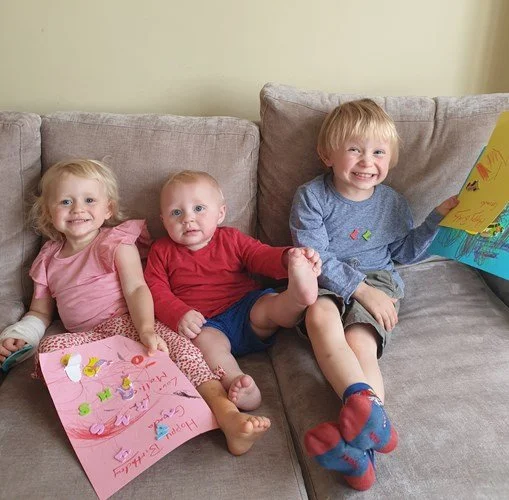  (L to R) Mollie, Ben and Leo sitting on a couch at home.  
