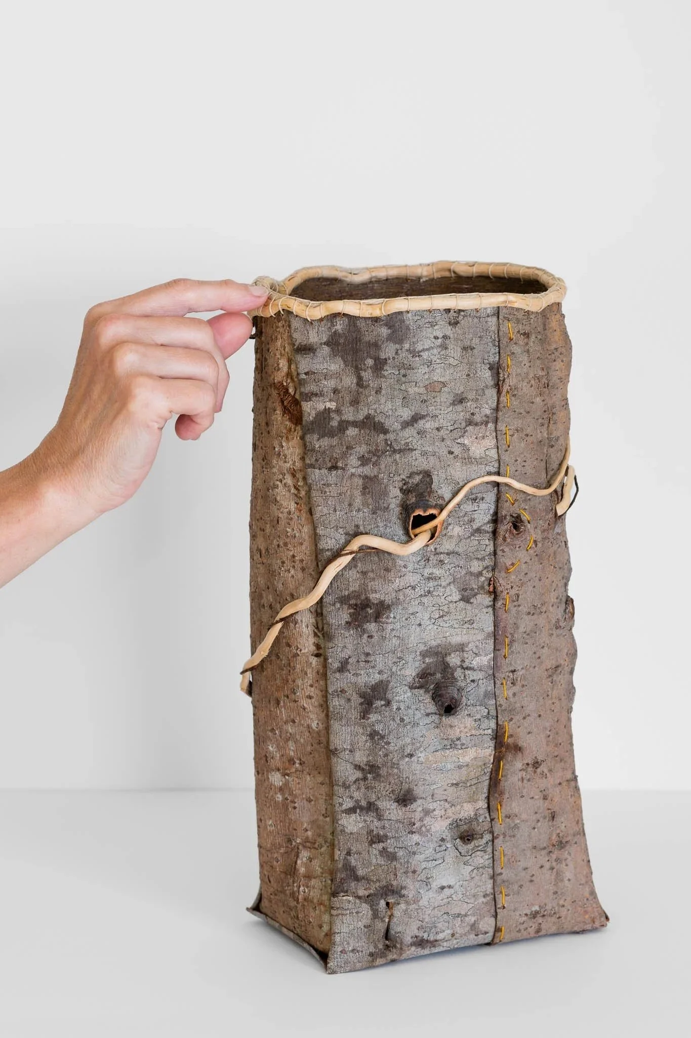 The Material has Memory (knothole) 2024 l Willow tree barks, stitched. Cedar root rim and wrap detail. 14 x 6.5 x 4.25 inches