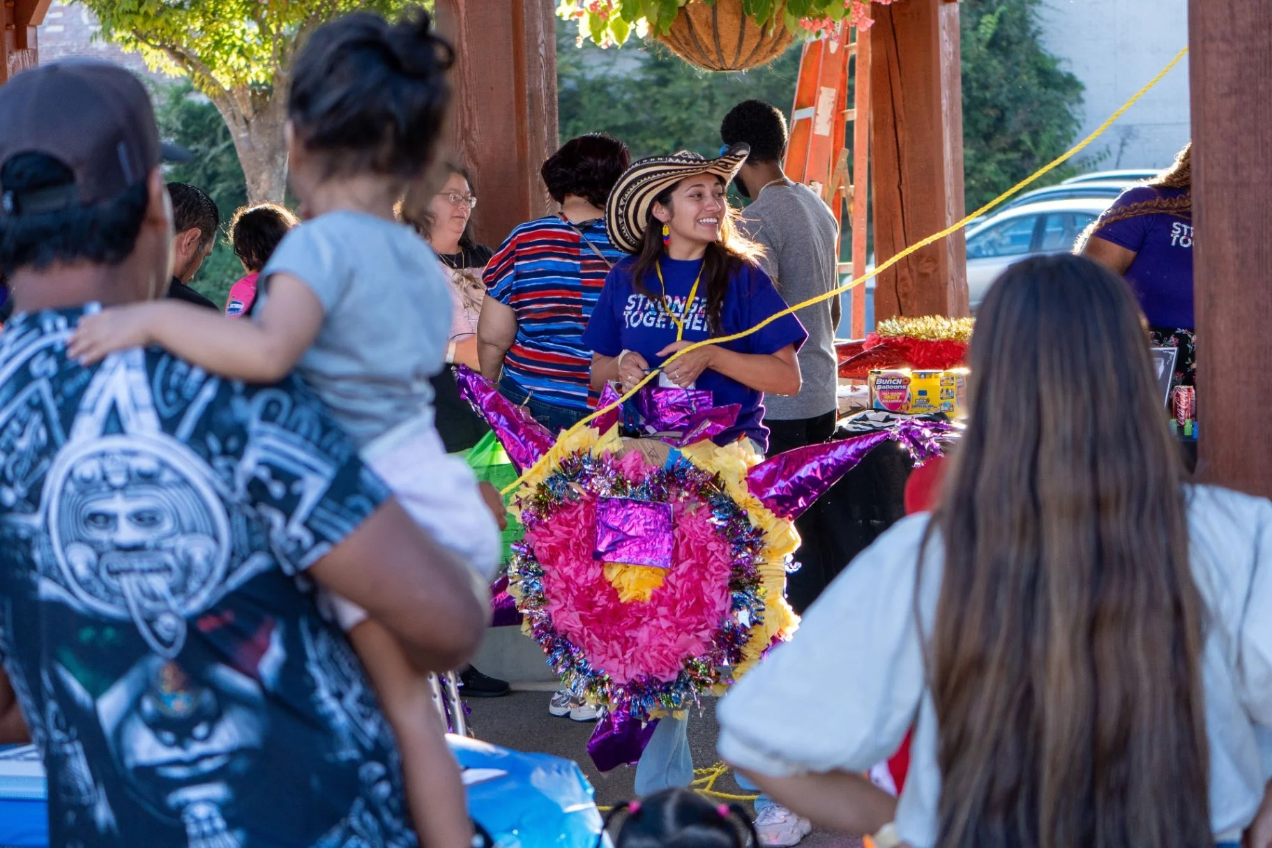 Community members celebrating at Latinx LIFE event with colorful piñata