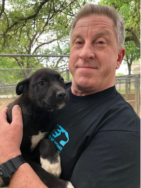 Robert holding black puppy