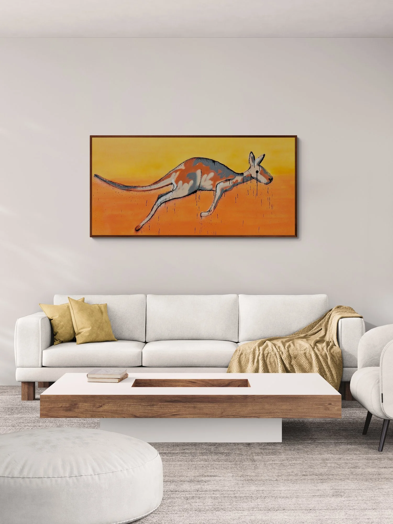 Modern living room with white sofa, beige throw blanket, yellow pillows, a white round ottoman, and a wooden coffee table with a recessed center, featuring a colorful painting of a kangaroo on the wall.