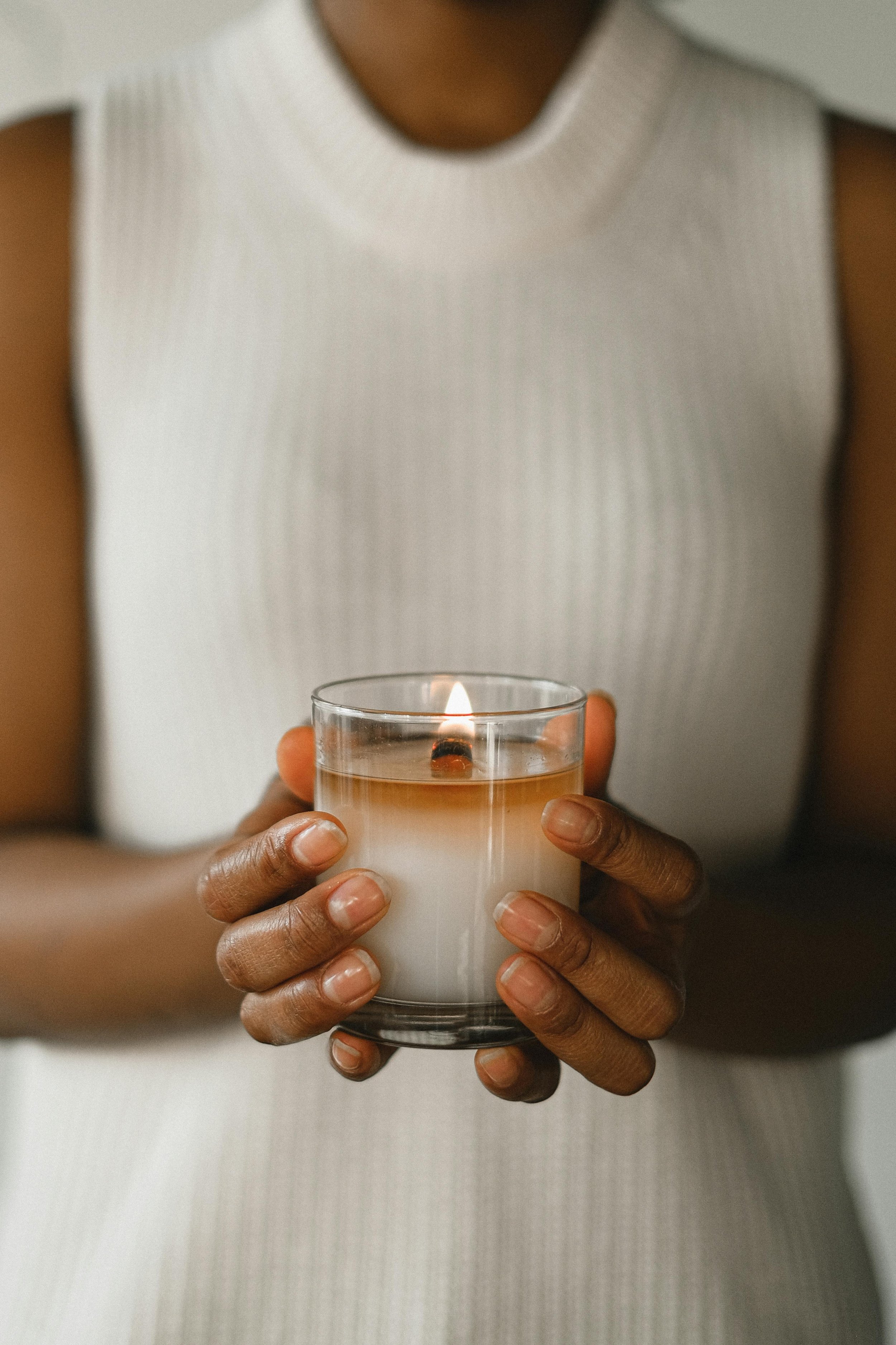Women Carrying Campfire Sparks Candle in a minimalist background. Enjoying the Aromatherapy of the Campfire Candle.