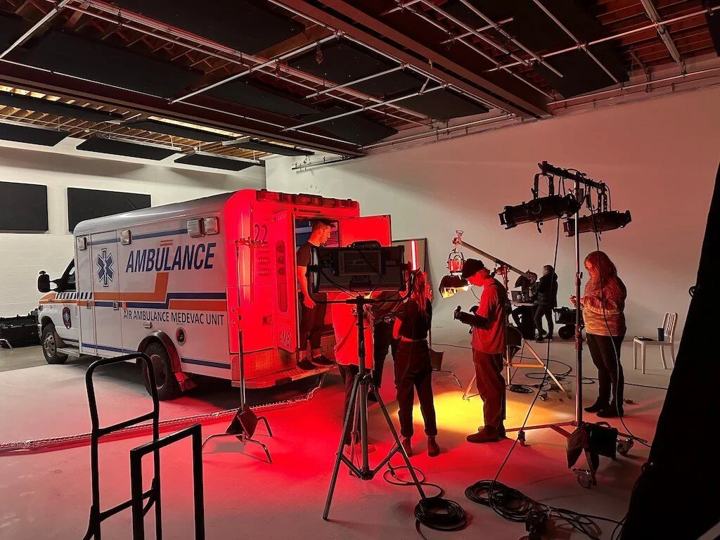 Film set with ambulance, lighting equipment, and crew
