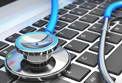 Stethoscope resting on a laptop keyboard.