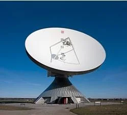 Large satellite dish antenna with a clear blue sky background.