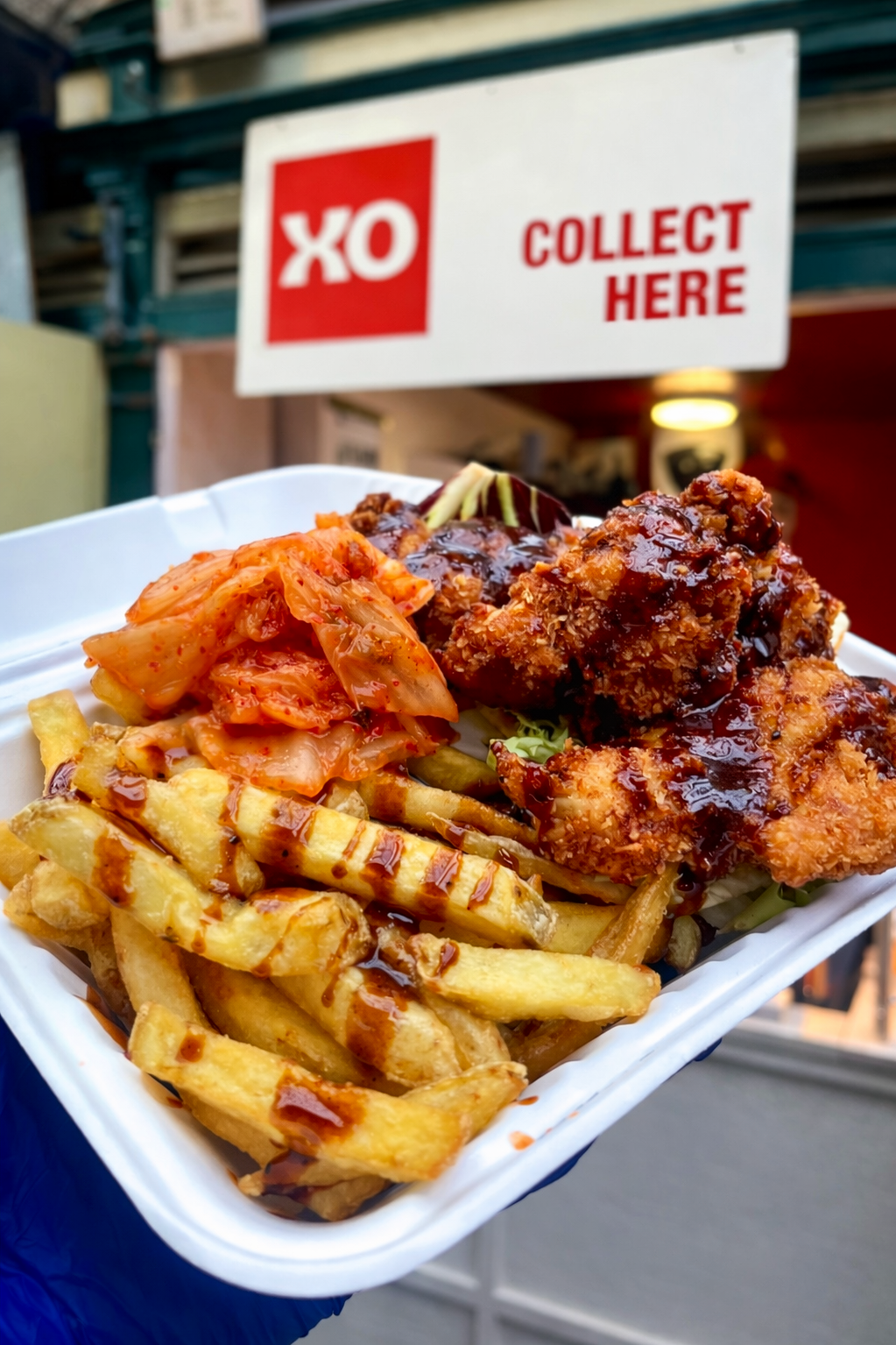 Crispy fries topped with juicy fried chicken, drizzled in bold sauce and served with sides like kimchi or salad for balance.