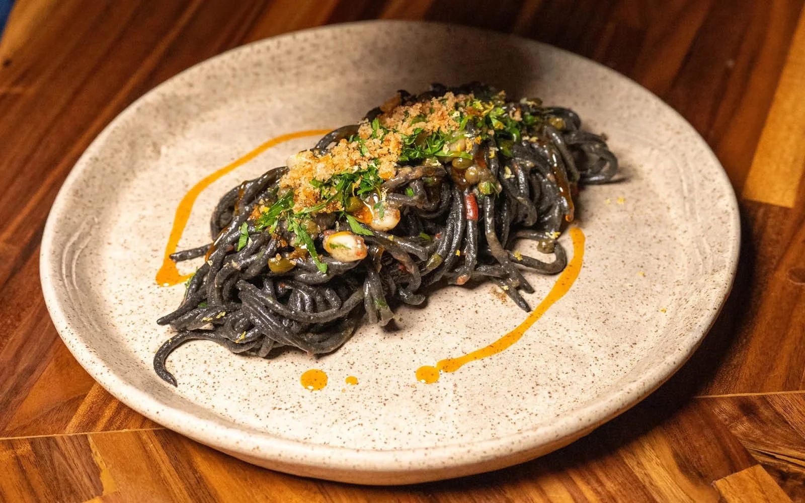  Pasta Puttanesca: Squid Ink Chitarra, Black Anchovies, Fresno Chiles, Garlic, Capers, Lemon Juice, Breadcrumbs, Calabrian Chile Oil, Lemon Zest, Parsley 