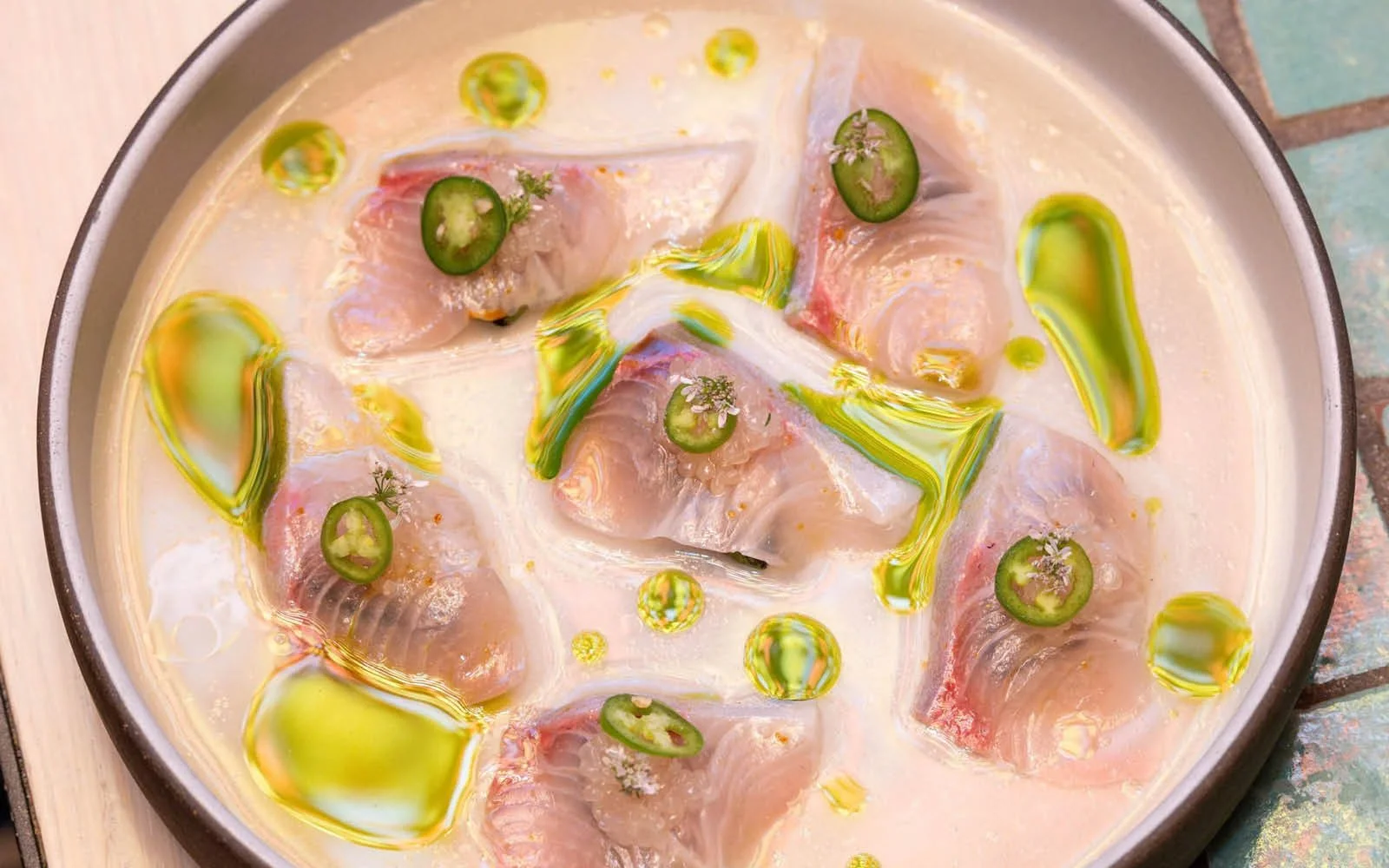  Kampachi Crudo, Tomato Dashi, Fermented Chile Purée, Charred Avocado, Ají Amarillo Salt, Finger Limes, Serrano Chile, Cilantro Oil, Cilantro Flower 