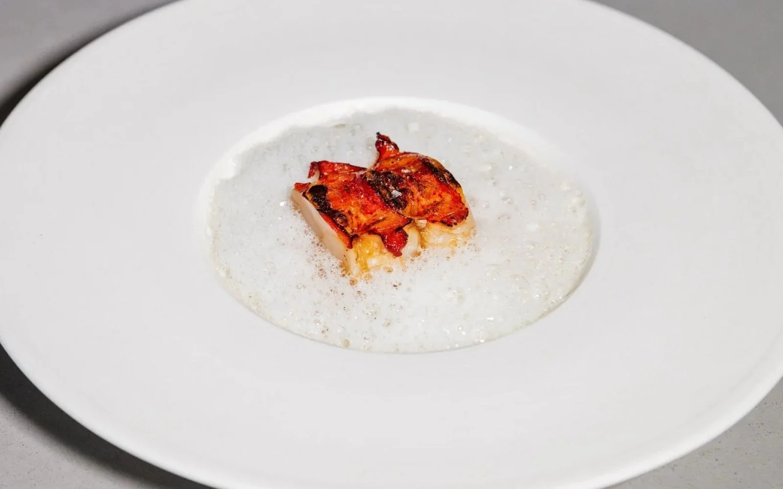  Grilled Lobster Tail, Spicebush Syrup, Lobster Cream, Roasted Lobster Butter, Green Tomato Juice Foam, Grilled Trout Roe, Crispy Chicken Skin 